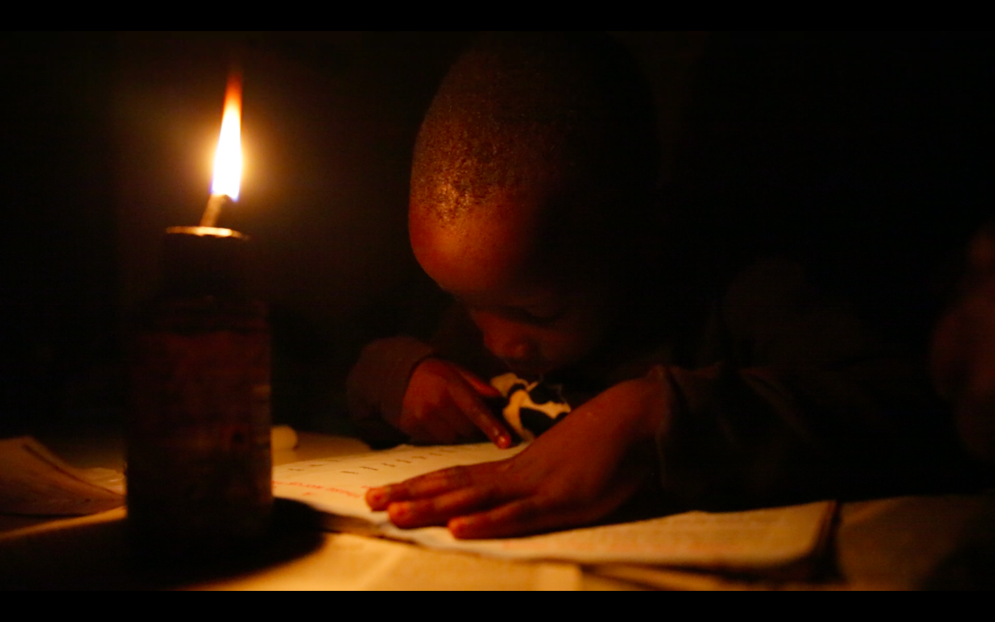 boy reading by candle light